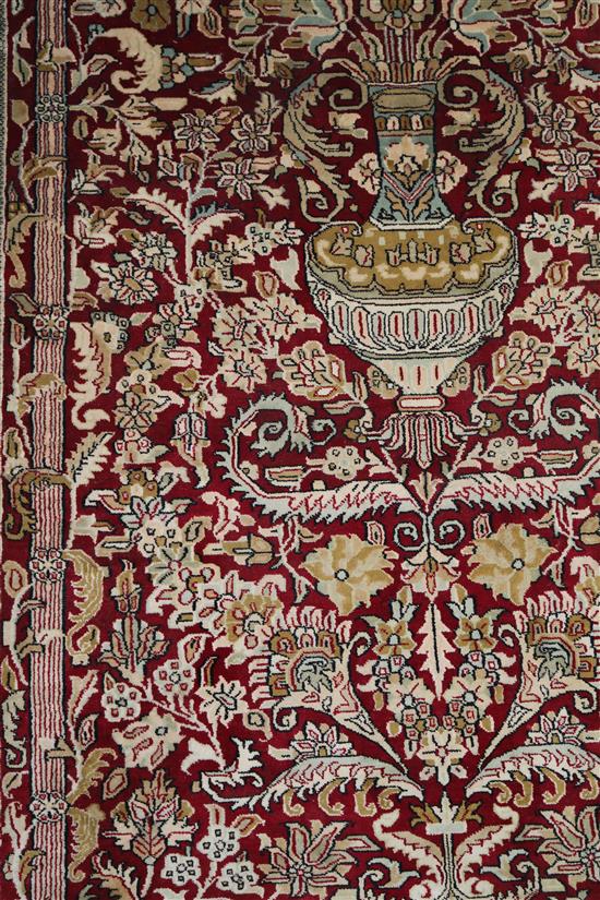 An Indian silk red ground rug